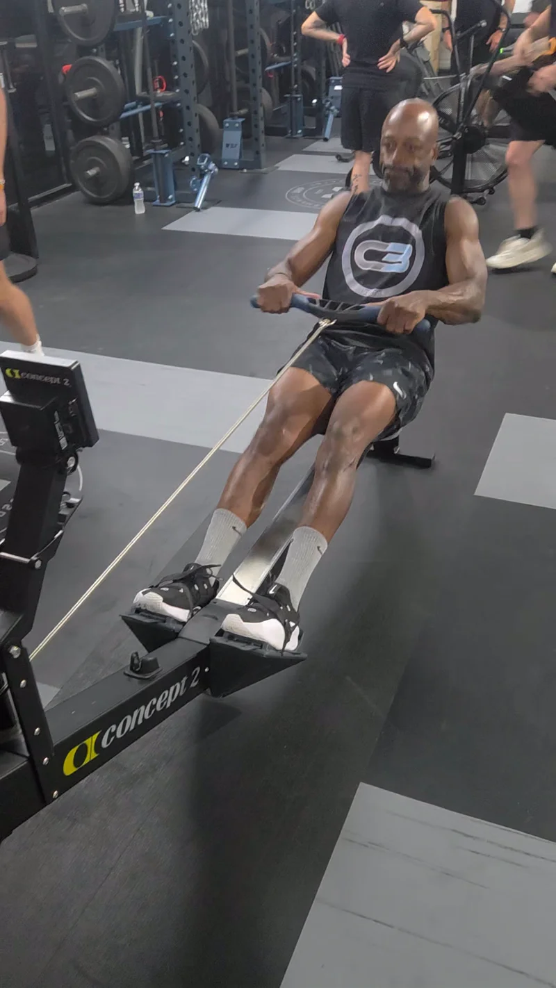 Cedric Bailey mid-effort on a Concept 2 rower, wearing C3 Fitness apparel